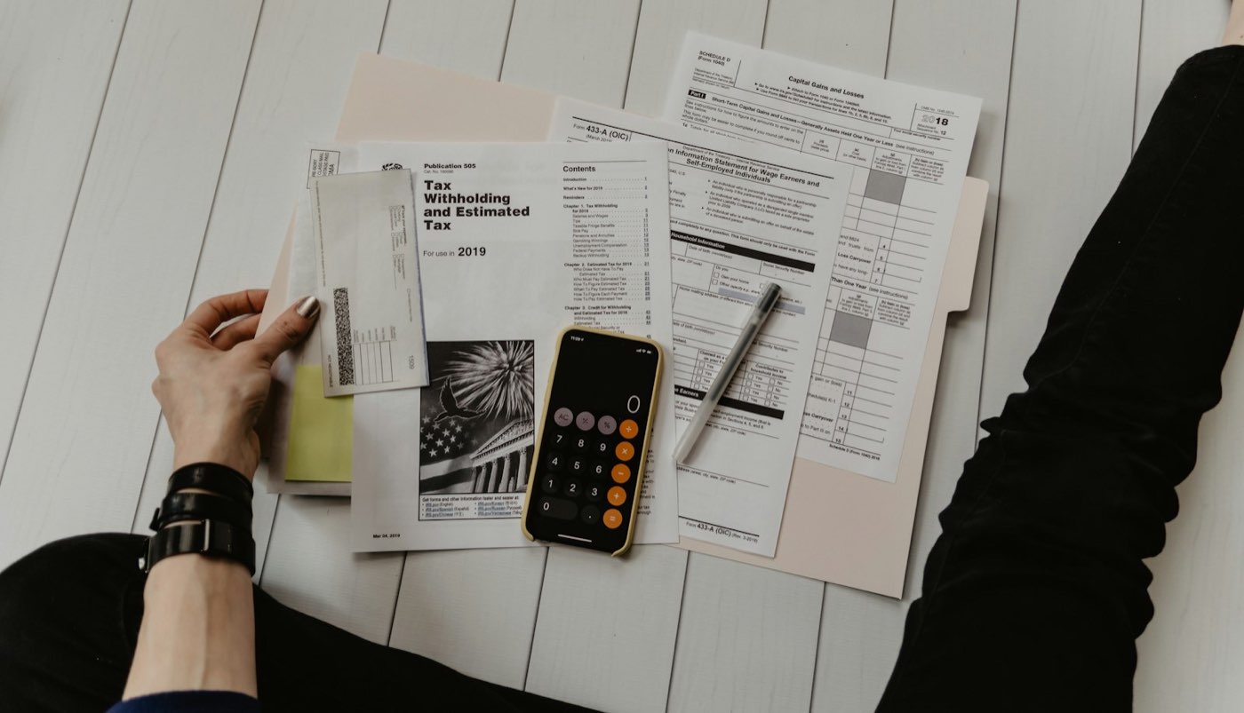 Reports, tables and a calculator laid out on a desk for review